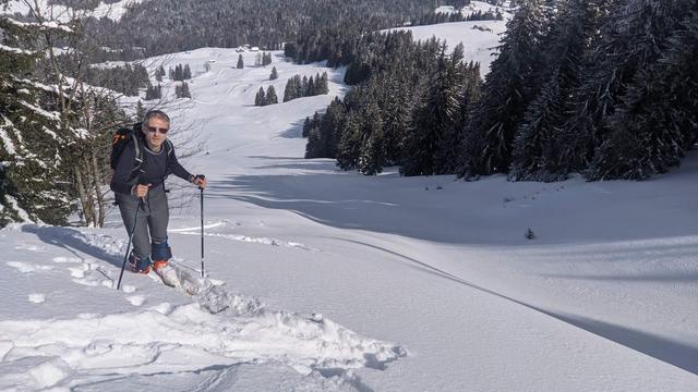 Roland steigt mit Schi einen Hang hinauf